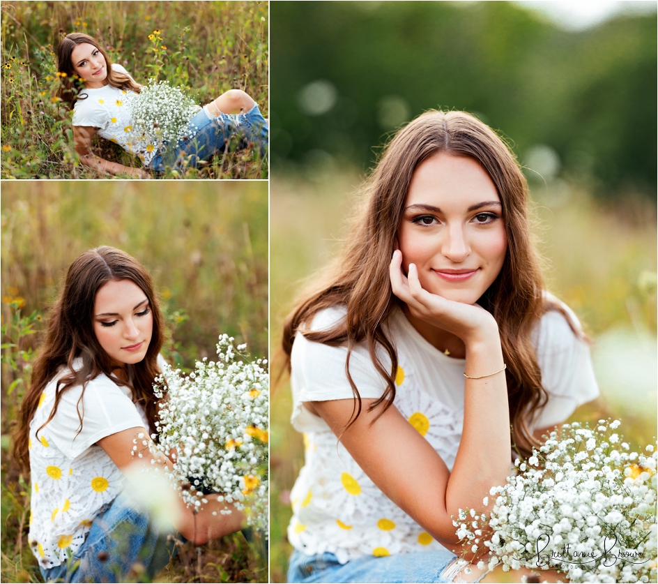 Senior pictures of a girl in a field, holding baby's breath.