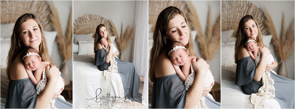 Mom holding her newborn daughter in a soft, light-filled studio.