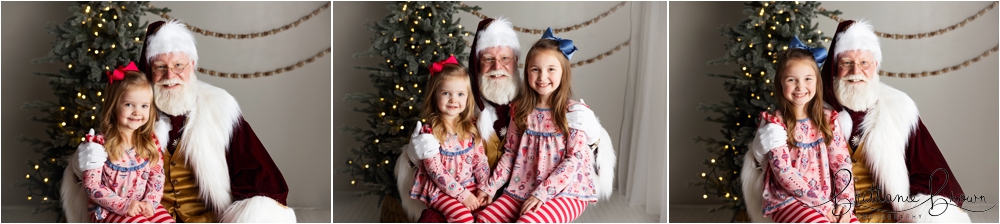 A family smiling with Santa in a holiday-themed studio.