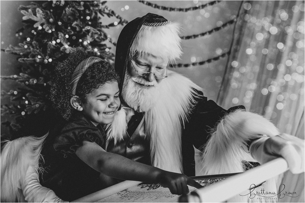 Santa showing a child their name on the Nice List.