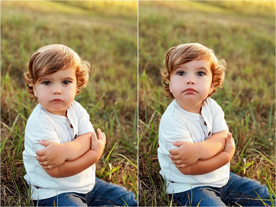 Toddler with his arms crossed after fake falling onto the grass.
