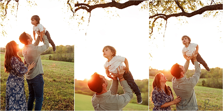 Dad holding sun up overhead during sunset.